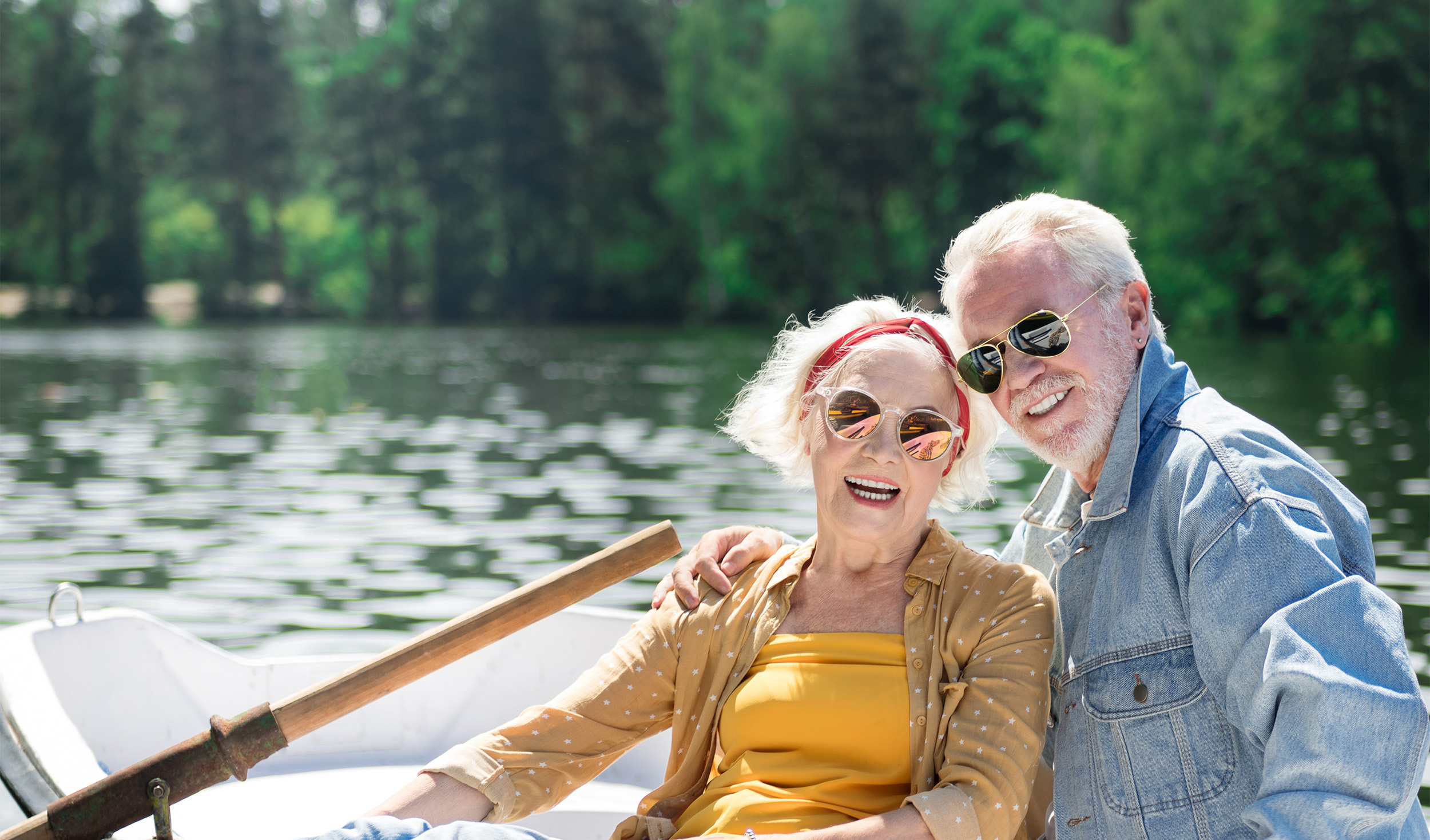 Senior couple at the lake wearing sunglasses to protect their eyes.